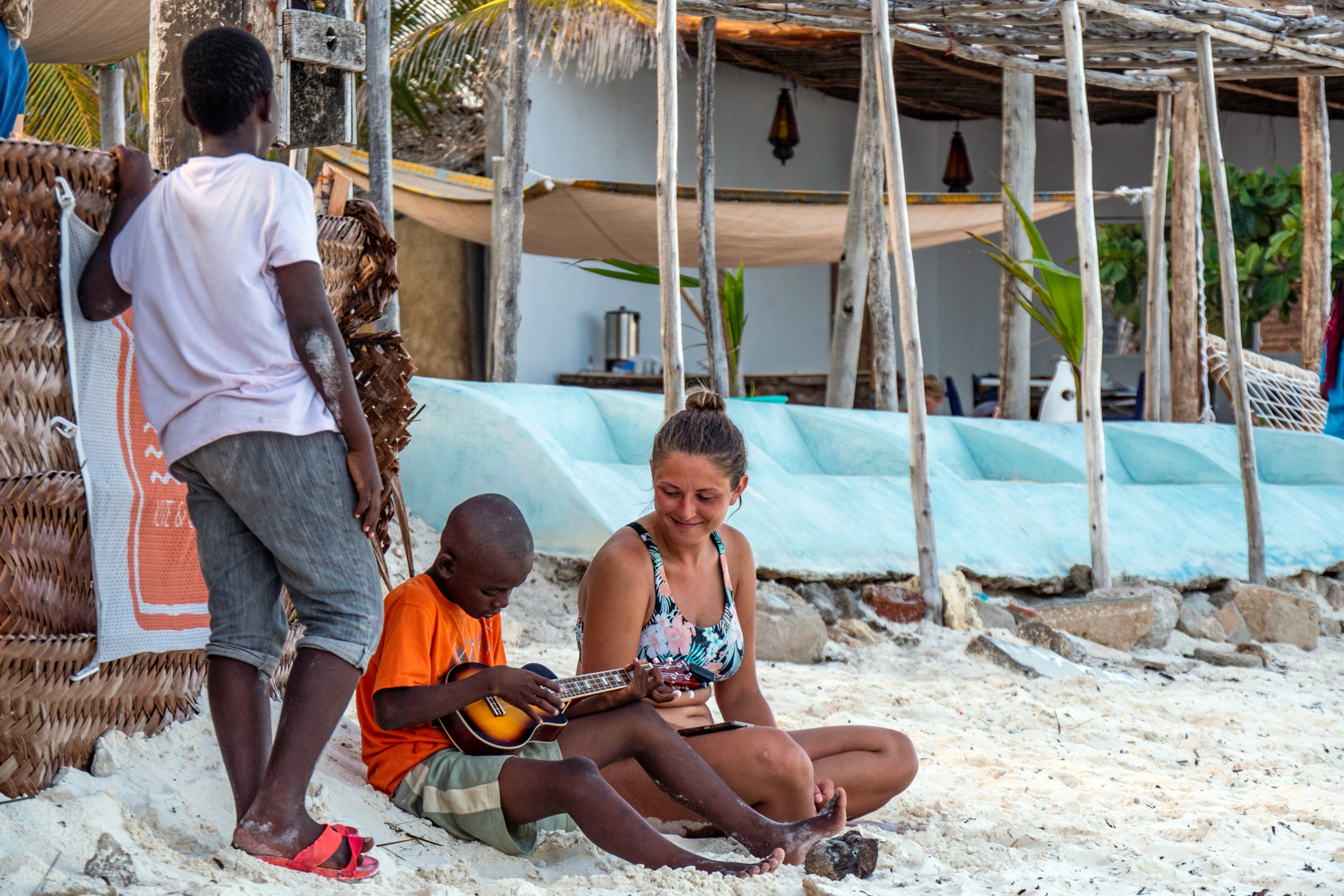 Local children and a tourist sharing a happy beach moment in Zanzibar
